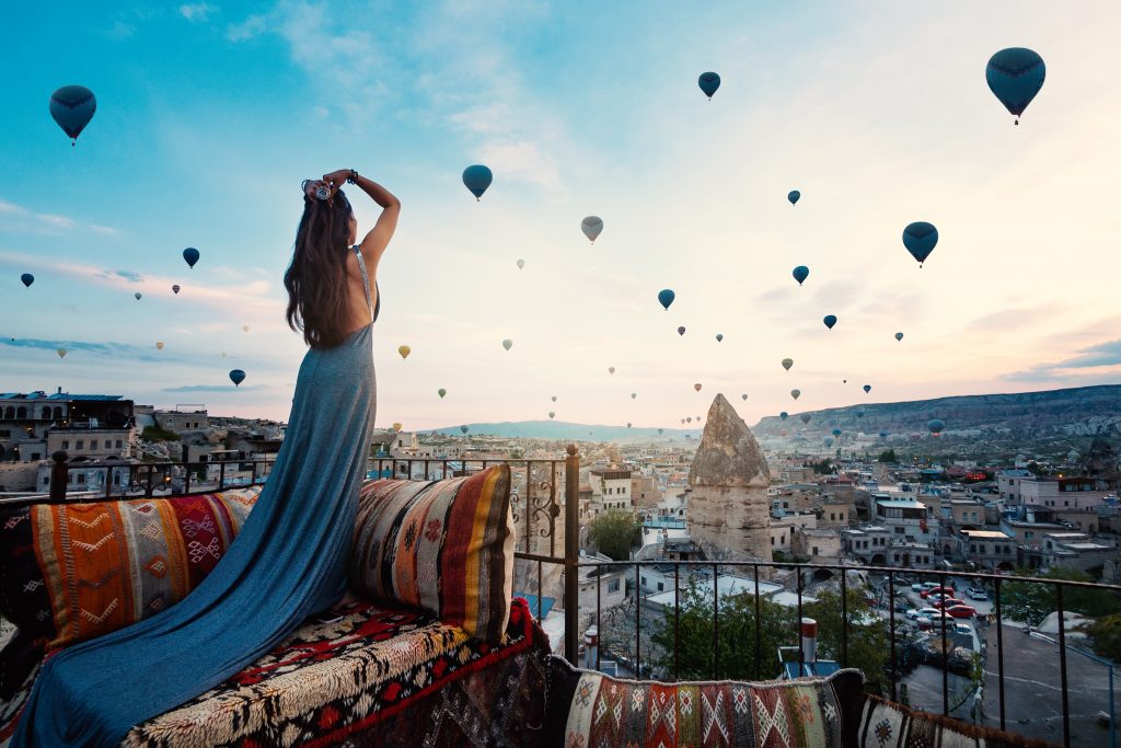 young beautiful woman wearing elegant long dress front cappadocia landscape sunshine with balloons air turkey 1024x683 1